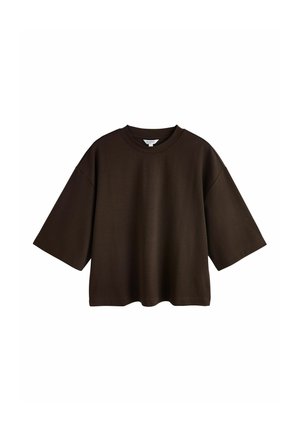 Donkerbruine oversized T-shirt met korte mouwen en een ronde hals, afgebeeld op een witte achtergrond.