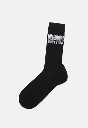 Chaussette noire en coton avec texture côtelée et logo "Billionaire Boys Club" imprimé sur le côté. Design classique de longueur mi-mollet.