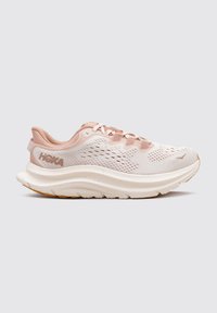 Zapatillas de running rosa claro con una parte superior de malla transpirable, media suela blanca y suela de goma texturizada; cuenta con cordones y logo en el talón.