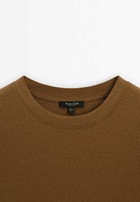 Brun ribbet bomulds sweatshirts med rund hals og synlige syninger. Etiketten indeni viser brand- og størrelsesoplysninger.