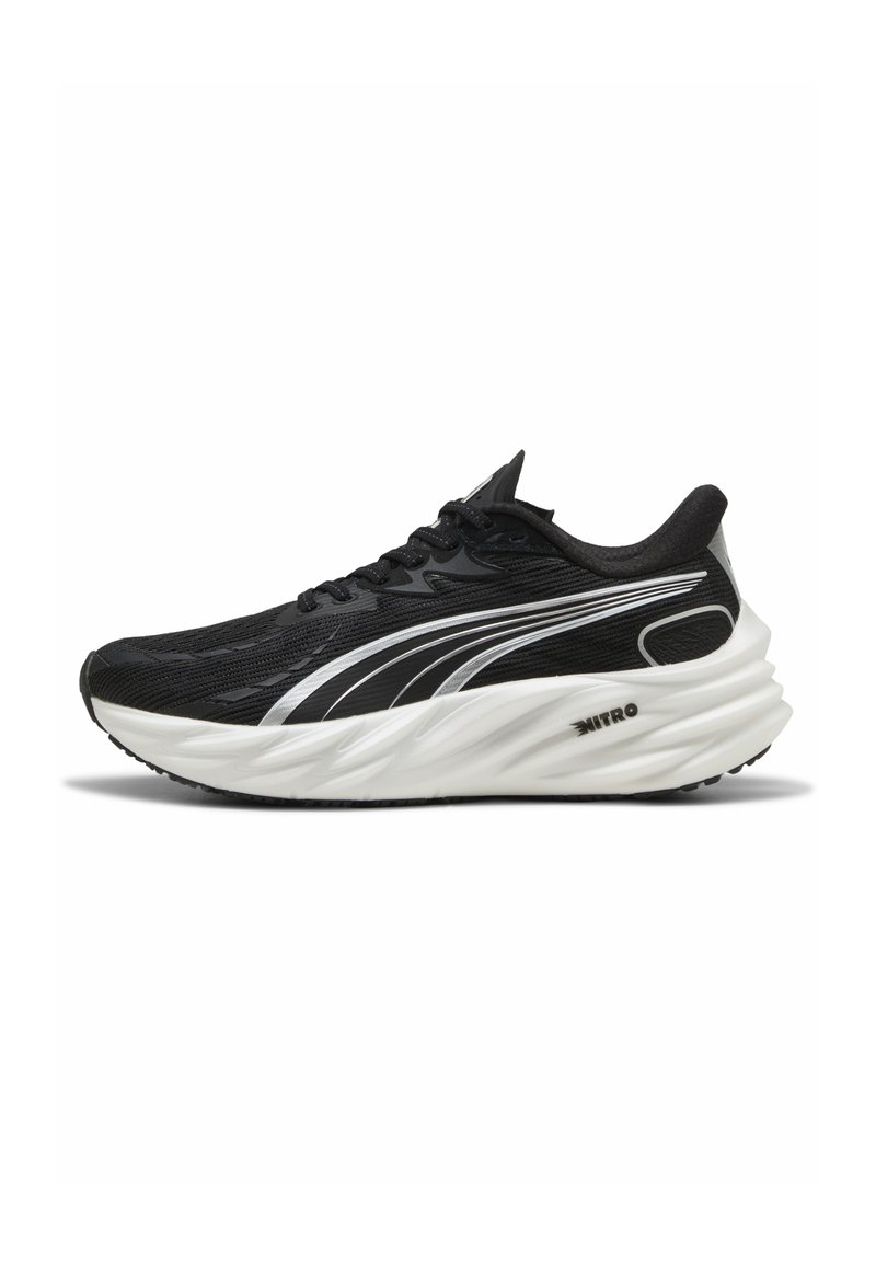 Chaussures de sport noires avec une tige texturée, des accents argentés et une semelle épaisse et blanche en mousse, présentant un design en forme de vague distinctif.