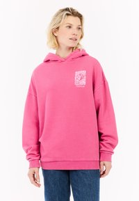 Sweatshirt à capuche rose en coton doux, avec un petit design graphique sur la poche avant. Coupe décontractée avec des poignets et un ourlet côtelés.
