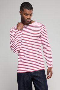 Rød og hvid stribet langærmet skjorte lavet af blødt stof, med bådudskæring og let stræk. Sammen med mørkeblå jeans.