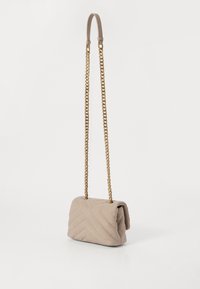 Beige quiltet taske med en fold-over klap, guld kædetræk og tekstureret chevron mønster. Kompakt rektangulær form.