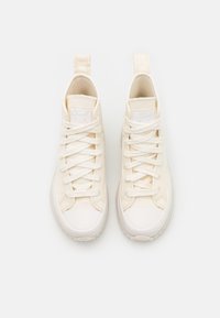 Höga sneakers med en texturerad krämfärgad canvasöverdela, vita snören, förstärkt tåhätta och subtil logotyp på tungan.