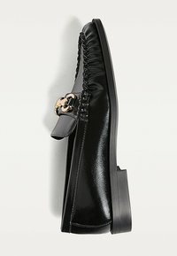 Svarta lädersneakers med rundad tå, samlade sidor och detaljer i gulguld. Platt sula med en minimalistisk design.