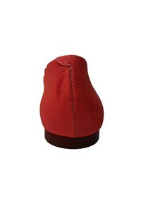 Zapato de ante rojo con un tacón redondeado. Presenta costuras visibles a lo largo de la costura trasera y una textura suave y mate. No tiene adornos.