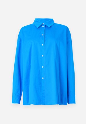 Plava košulja s dugim rukavima i šiljastim ovratnikom, ravnog kroja. Glatka pamučna tkanina s kontrastnim bijelim gumbima.