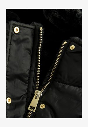 Svart puffjacka med en guldglänsande dragkedja och tryckknappar, med en mjuk pälsfodrad krage och en slät, glänsande tygstruktur.
