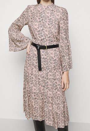 Robe longue à manches longues, à fleurs roses avec des accents noirs, dotée d'un devant boutonné et d'une ceinture noire à la taille. Manches évasées et design à volants.