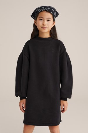 Schwarzes, übergroßes Sweatshirt-Kleid mit langen Puffärmeln und einem gerippten Kragen. Verfügt über dezenten, gestickten Text auf der Vorderseite.