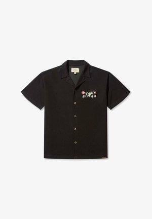 Camicetta nera a maniche corte con bottoni, realizzata in tessuto leggero, con scritta ricamata "PAS DE MONACO" in lettere floreali colorate.