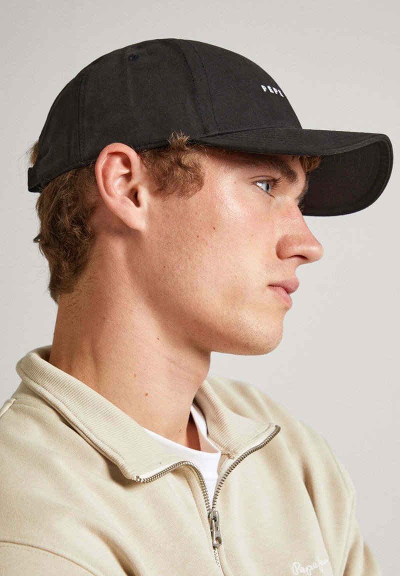 Gorra de béisbol negra con visera curva, con un sutil logotipo en la parte frontal. La tela es suave con un acabado mate.