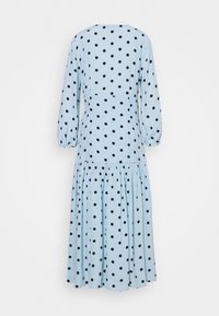 Robe bleu clair avec des pois noirs, dotée de longues manches bouffantes et d'un ourlet empilé et froncé. Fabriquée en tissu doux et léger.