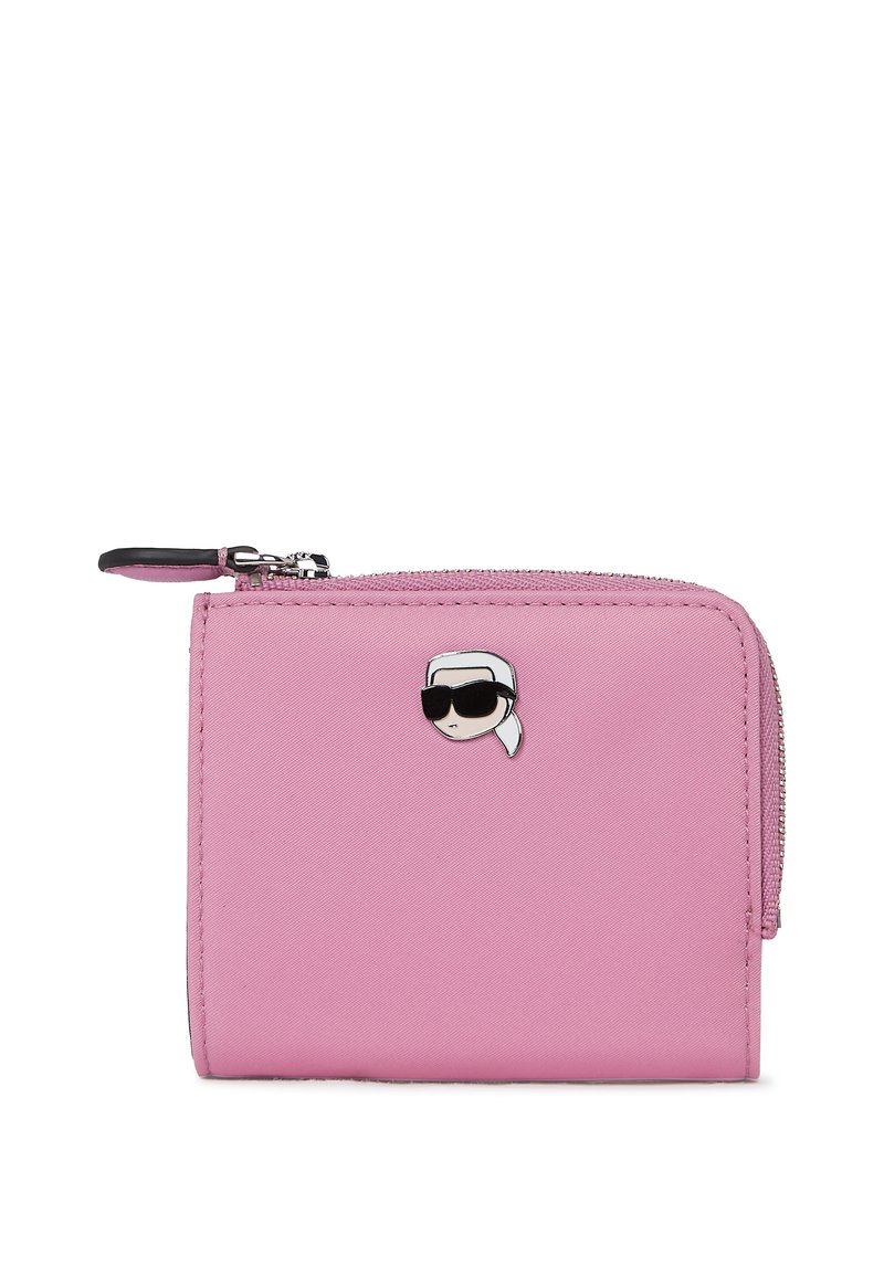 Ροζ πορτοφόλι με φερμουάρ, φτιαγμένο από υλικό με υφή, με έναν μικρό καρτούν χαρακτήρα με γυαλιά ηλίου ως διακοσμητικό στοιχείο μπροστά.