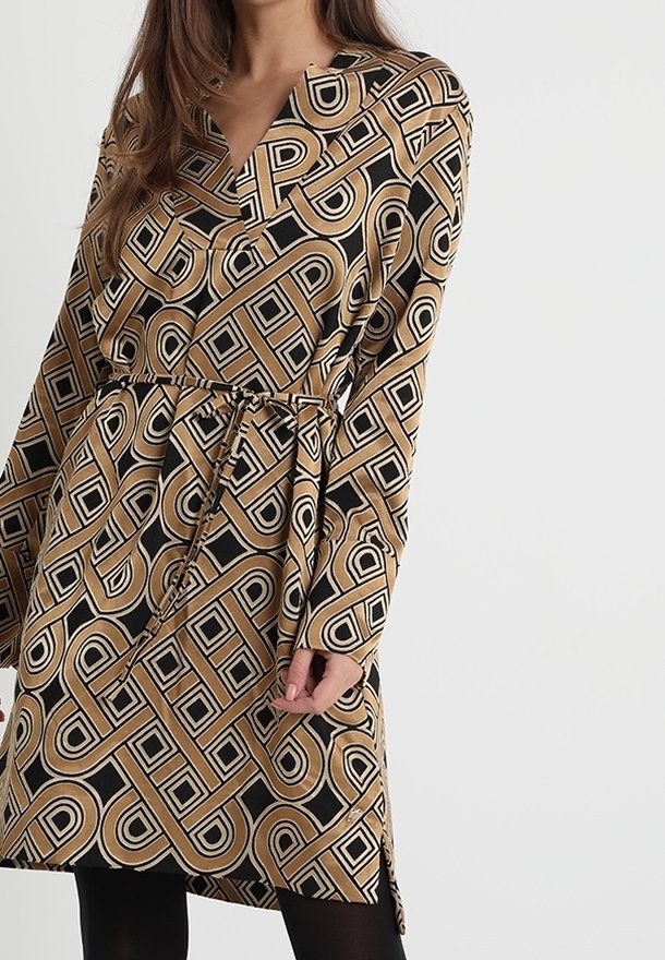 Langärmliges Kleid mit V-Ausschnitt, braunem und schwarzem geometrischem Muster, tailliertem Bund und seitlichen Schlitzen für mehr Bewegungsfreiheit. Glatte Stoffoberfläche.