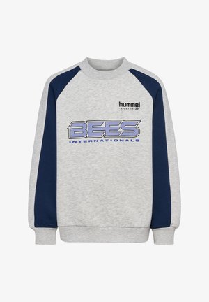 Szara bluza z granatowymi raglanowymi rękawami, z logo "hummel SPORTSWEAR" i grafiką "BEES INTERNATIONALS" w niebieskich literach. Miła w dotyku.