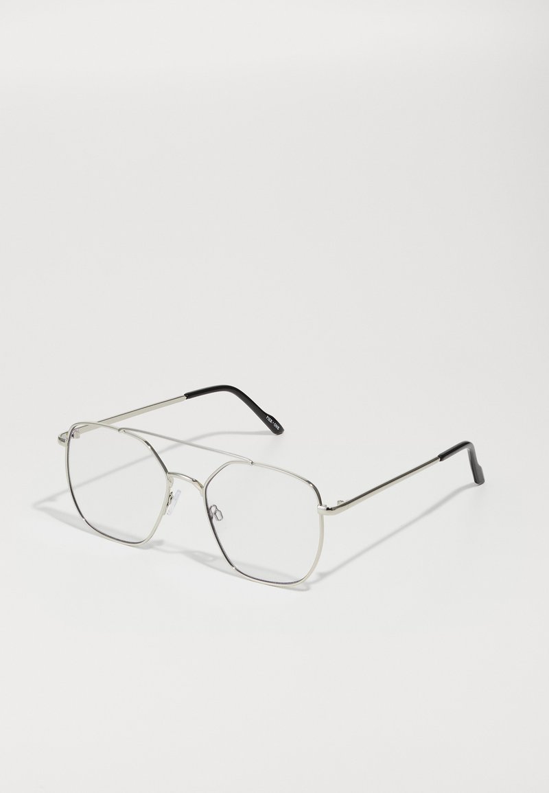 Gafas de metal plateadas con una forma geométrica octogonal, lentes transparentes y puntas negras en las patillas. Diseño minimalista con montura delgada.