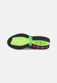 Fekete sneaker talp élénk zöld középtalppal, amelyen kör alakú piros díszek találhatók. A talp mintázata megemelt tapadási felületekkel rendelkezik a jobb tapadás érdekében.