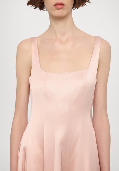 Roze satijnen jurk met een vierkante halslijn, smalle bandjes en geplooide rokdetails. Gladde textuur met een zachte glansafwerking.