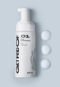 Weiße Pumpflasche mit der Aufschrift "GET RID OF 01" und grünem Wellenmuster. Begleitet von drei hellblauen Schaumhäufchen auf einem sanften grauen Hintergrund.
