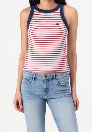 Paski top w czerwono-białe poziome paski, granatowy dekolt i wycięcia na ręce; prążkowana tkanina; noszony z jasnoniebieskimi dżinsami.