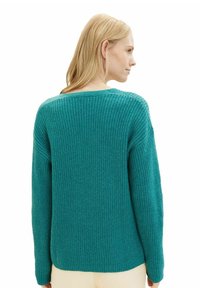 Türkisfarbener Strickpullover mit lässiger Passform, der über eine gerippte Textur, weite Ärmel und einen Rundhalsausschnitt verfügt. Die Rückansicht zeigt minimale Details.