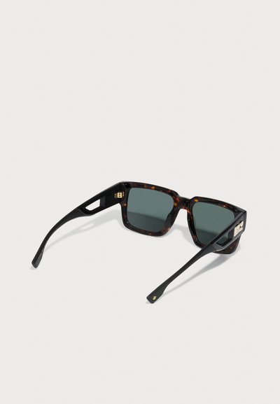 Tortoiseshell sunglasses with dark green lenses, angular frame design, black arms, and gold hardware accents on the side.
