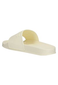 Infradito color crema con una fascia ampia e una soletta strutturata, caratterizzato da una suola piatta e un design minimalista. Nessun marchio visibile.