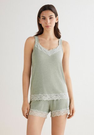 Lichtgroene slaapset met een top en shorts. Kantafwerking langs de halslijn en zoom voegt detail toe. Zachte stof met een ontspannen pasvorm.