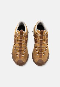Scarpe da trekking in suede marrone e tessuto con lacci decorati, suole in gomma e una presa testurizzata. Presentano un collare imbottito e una punta rinforzata.
