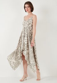 Lichtgewicht, beige jurk met dierenprint, V-hals en asymmetrische zoom. Heeft spaghetti bandjes en valt soepel.