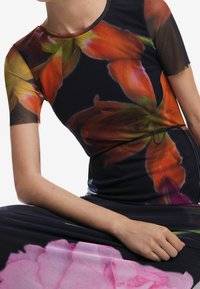 Robe ajustée avec un motif floral dans des nuances d'orange et de rose sur fond noir. Manches courtes et encolure ronde.