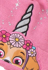 Roze gebreide muts met een cartoonhond met een bloemenkrans en een zilveren spiraalvormige hoorn. Sprankelende accenten en sterrenpatronen zijn zichtbaar.