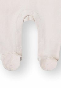 Pelele para bebé de color rosa claro con cierres de presión, que presenta suaves detalles moteados en crema claro en los pies, diseñado para la comodidad y facilidad de uso.