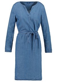 Robe longue en denim bleu à manches longues avec une poche poitrine devant, un col en V et une ceinture en tissu assortie nouée à la taille.