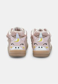 Un paio di sneakers rosa per bambini con facce di unicorno sorridenti, orecchie e corna sul retro, su uno sfondo bianco semplice.