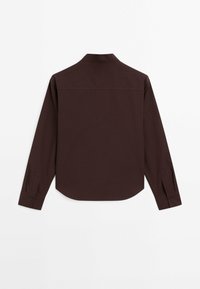 Chemise à manches longues bordeaux foncé avec col, ourlet arrondi et poignets boutonnés. Fabriquée en tissu lisse, avec un design épuré et minimaliste.