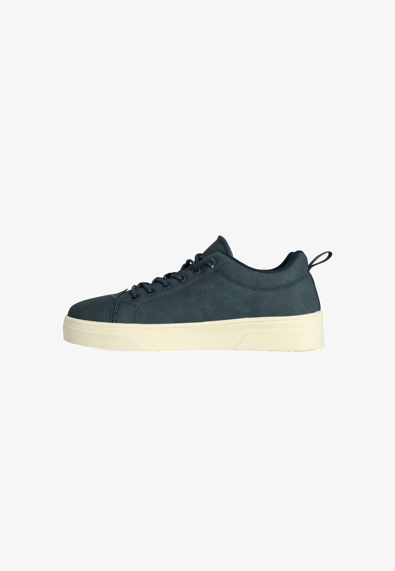 Tmavě modré kožené tenisky s kulatou špičkou, plochou bílou gumovou podrážkou a tmavě modrými šňůrkami; mají malý poutko na patě pro snadné obouvání.