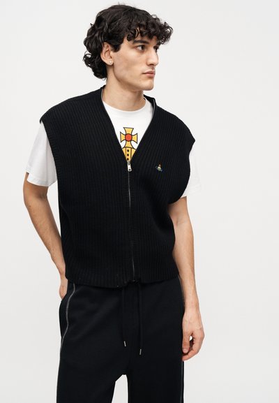 Μαύρο ριμπ ζιβάγκο με φερμουάρ και κοντά μανίκια, φορεμένο πάνω από ένα λευκό μπλουζάκι με γραφικό σχέδιο. Λείο ύφασμα, άνετη εφαρμογή.