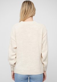 Hellbeiger Strickpullover mit Rundhalsausschnitt, gerippten Bündchen und Saum. Bietet eine lockere Passform und ein strukturiertes Maschenmuster.