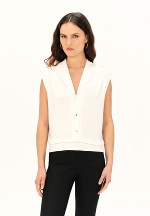 Witte mouwloze top met een uitgesneden kraag, knopen aan de voorkant en een strakke zoom. Gecombineerd met zwarte broek. Gladde stof met een minimalistisch ontwerp.