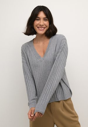 Maglione grigio a coste con scollo a V e maniche lunghe, caratterizzato da una vestibilità comoda e un tessuto testurizzato, abbinato a pantaloni beige.