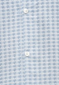 Lichtblauw overhemd met knopen en een gestructureerd ruitpatroon, voorzien van witte knopen en een zachte, geweven stof.