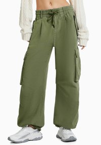 Gröna cargobyxor i mjukt tyg, med elastisk midja och dragsko, sidofickor och en avslappnad, vid ben-design.