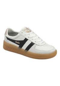 Sneaker sportive bianche con strisce nere e suola in gomma naturale. Presentano una tomaia liscia, perforazioni circolari e un accento rosa sul tallone.