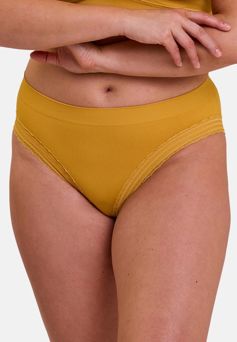 Culotte de bikini en mélange de coton jaune avec une large ceinture élastique et une bordure en dentelle le long des ouvertures de jambe. Texture lisse, coupe taille mi-haute.