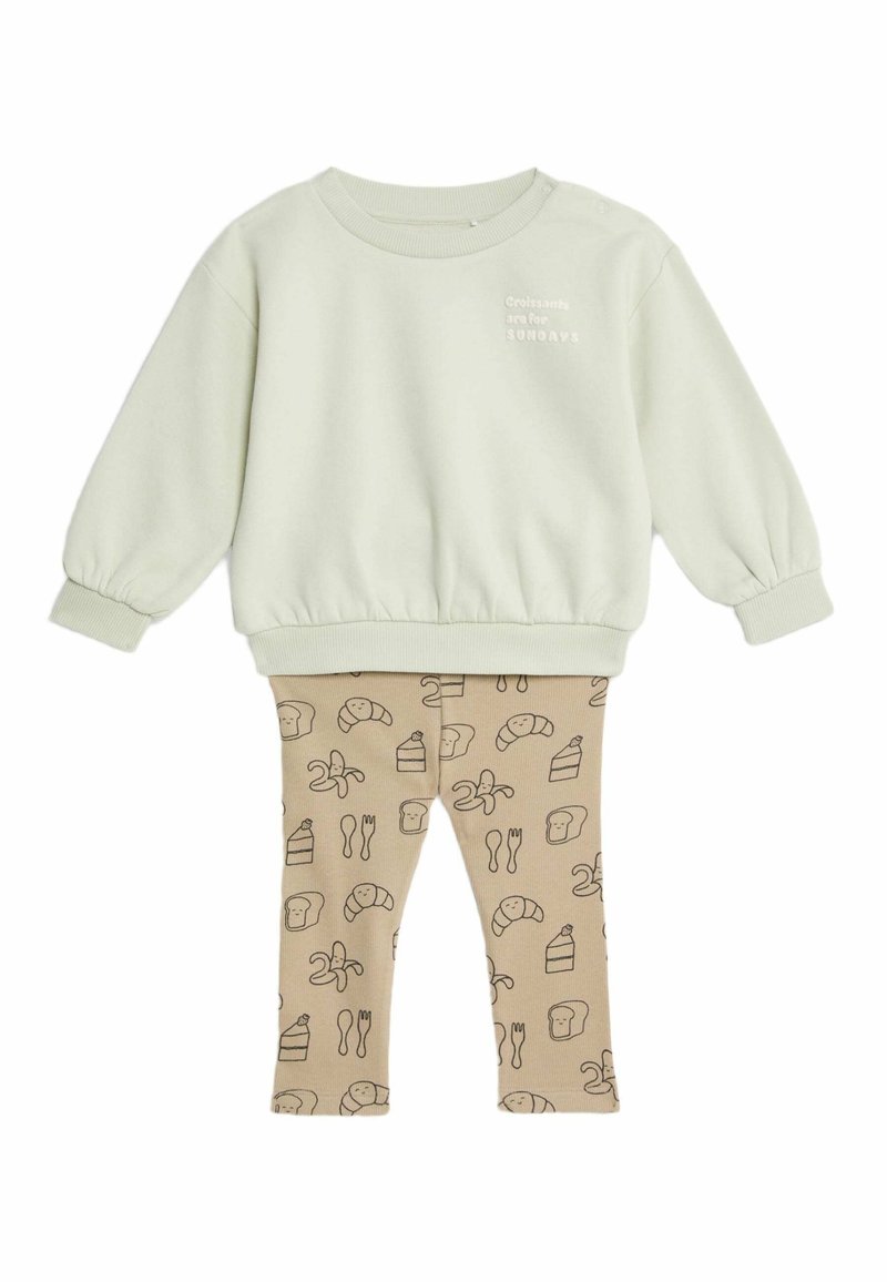 Felpa in cotone verde chiaro con polsini elasticizzati e testo "I croissant sono per la DOMENICA". Leggings beige con una stampa di cibo in marrone.
