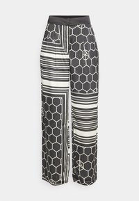 Pantalon à jambes larges avec un motif géométrique noir et blanc composé d'hexagones et de rayures. Confectionné dans un tissu lisse avec une taille structurée.