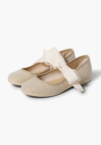 Bailarinas beige con un tejido de tela texturizado; cuentan con una ancha tira con un lazo en el tobillo y un diseño de punta redonda.
